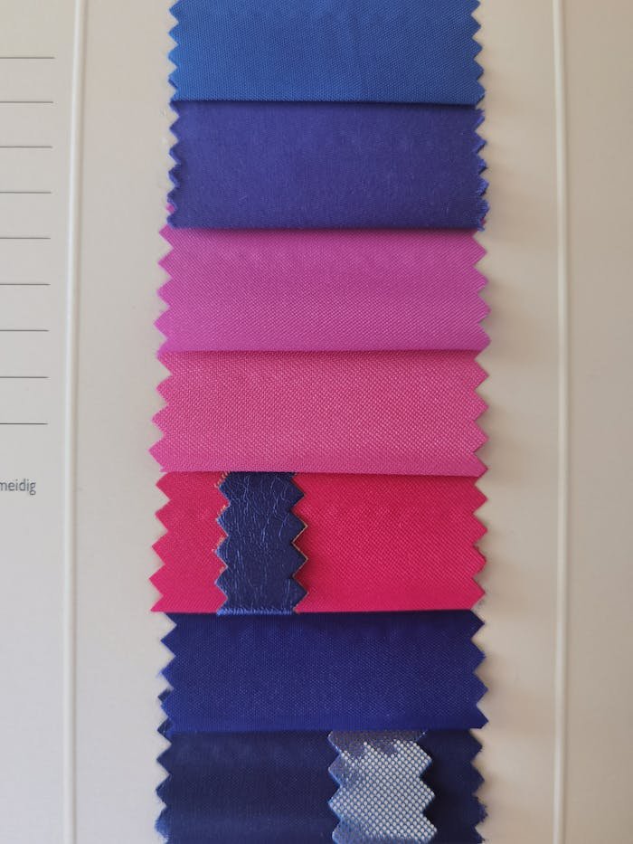 A vertical display of vibrant fabric swatches in blue and pink hues for design inspiration.
